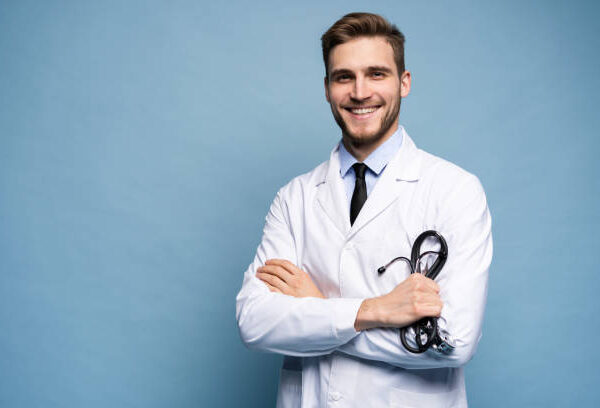 Portrait of confident young medical doctor on blue background